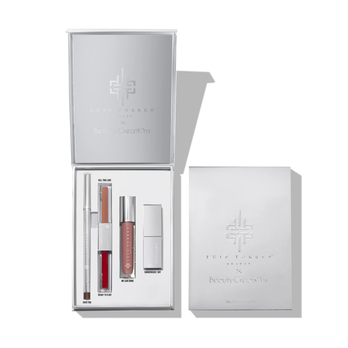 Un set de regalo de belleza plateado y abierto que muestra productos para labios: un delineador, labiales en barra, un labial velvet doble y un gloss, junto a su caja a juego, con una presentación elegante y minimalista.