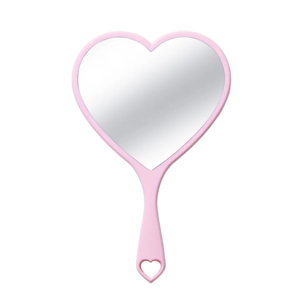 Un espejo de mano en forma de corazón con marco y mango de color rosa claro, con un pequeño recorte de corazón en el extremo, mostrado sobre un fondo blanco limpio.