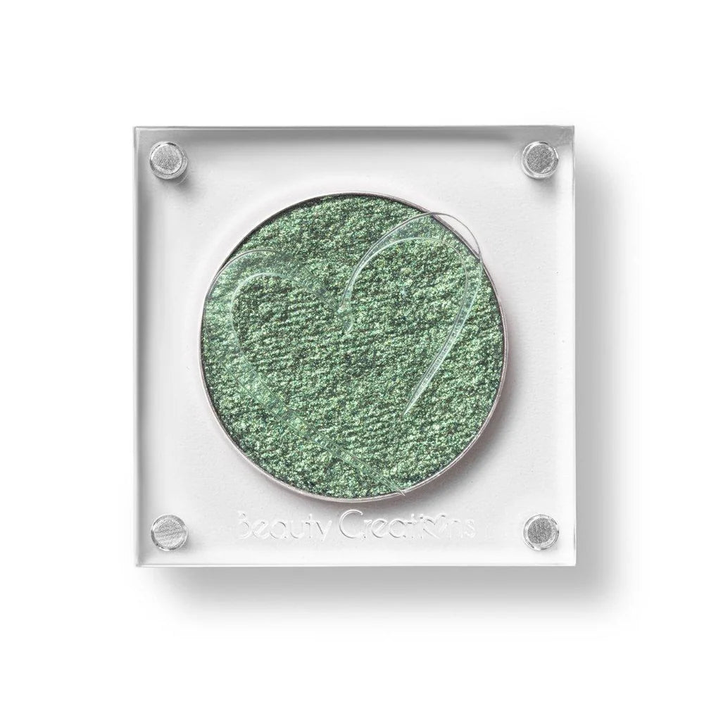 Un estuche cuadrado de sombra de ojos de Beauty Creations en acrílico transparente con un hueco redondo de sombra verde menta brillante, con un recorte en forma de corazón en la tapa.