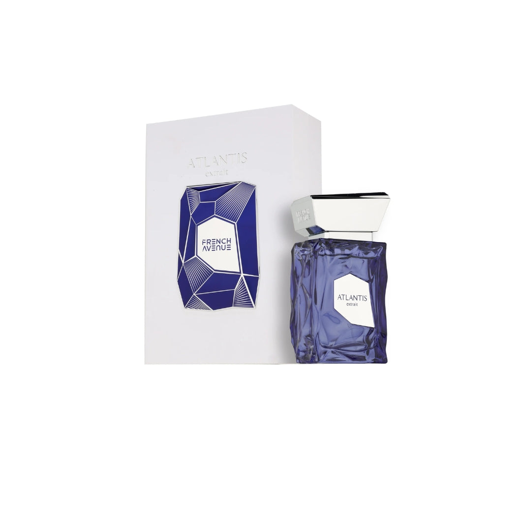 Botella de perfume "Atlantis Extrait" de French Avenue de vidrio esculpido en tono azul marino profundo con textura de roca tallada, etiqueta geométrica blanca en la parte inferior y un voluminoso tapón geométrico cromado plateado, junto a su caja blanca minimalista con la ilustración de una gema azul facetada en el frente.