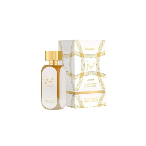 Botella de perfume rectangular de vidrio transparente con líquido de tono ámbar dorado "Hayaati Gold Elixir" de Lattafa de 100 ml, con etiqueta ovalada blanca en el frente y tapón rectangular dorado, junto a su caja blanca decorada con arcos e intrincados patrones geométricos en dorado y caligrafía árabe.