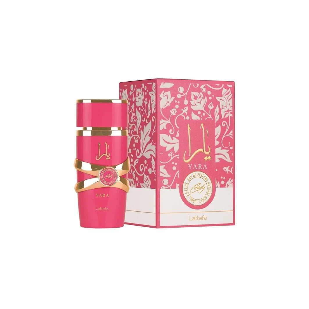 Botella de perfume cilíndrica de color rosa chicle o fucsia "Yara Candy" de Lattafa de 100 ml con un adorno entrelazado metálico dorado en el centro y tipografía en dorado, junto a su caja rosa con un patrón floral de encaje blanco y un sello circular central con el nombre "Candy".