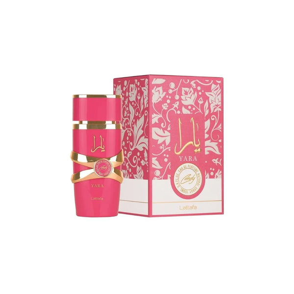Botella de perfume cilíndrica de color rosa chicle o fucsia "Yara Candy" de Lattafa de 100 ml con un adorno entrelazado metálico dorado en el centro y tipografía en dorado, junto a su caja rosa con un patrón floral de encaje blanco y un sello circular central con el nombre "Candy".
