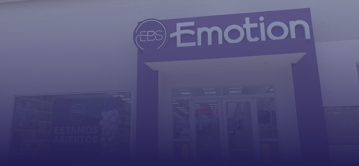 Fachada de una tienda Emotion con entrada enmarcada en color violeta y letrero de la marca sobre las puertas de cristal.