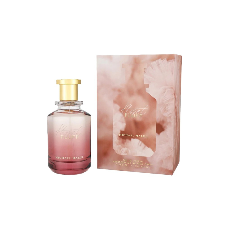 Botella de perfume Fluff de Michael Malul con un degradado en tonos rosados y una tapa dorada, junto a su caja a juego en color rosa empolvado, que transmite una sensación delicada y elegante.