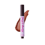 El tubo de brillo labial Plump & Pout se presenta de pie sobre un fondo blanco, con un swatch brillante en tono marrón detrás, transmitiendo una sensación fresca y pulida de producto de belleza.