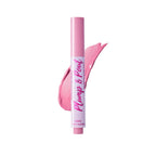 El tubo de brillo labial Plump & Pout se presenta de pie sobre un fondo blanco, con un swatch brillante en tono rosa bebé detrás, transmitiendo una sensación fresca y pulida de producto de belleza.