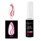 Un frasco de gel para uñas que brilla en la oscuridad de Legacy Nails junto a un tip de uña que muestra rayas rosa intenso de día y un brillo rosa intenso de noche.