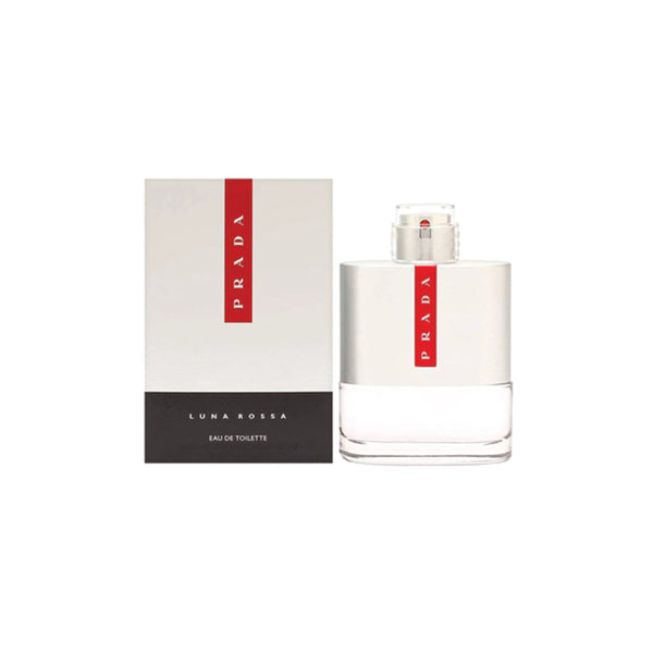 Botella de perfume "Luna Rossa" de Prada de 100 ml con base de vidrio transparente, cuerpo superior de metal plateado cepillado y la icónica franja roja vertical con el logo de la marca, junto a su caja plateada con la misma franja roja y base negra texturizada.