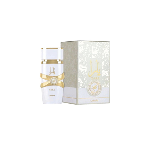 Botella de perfume cilíndrica de color blanco mate "Yara Moi" de Lattafa de 100 ml con un adorno entrelazado metálico dorado en el centro y tipografía árabe y latina en dorado, junto a su caja blanca con un patrón floral sutil en relieve, letras en dorado y un sello circular que dice "Moi".